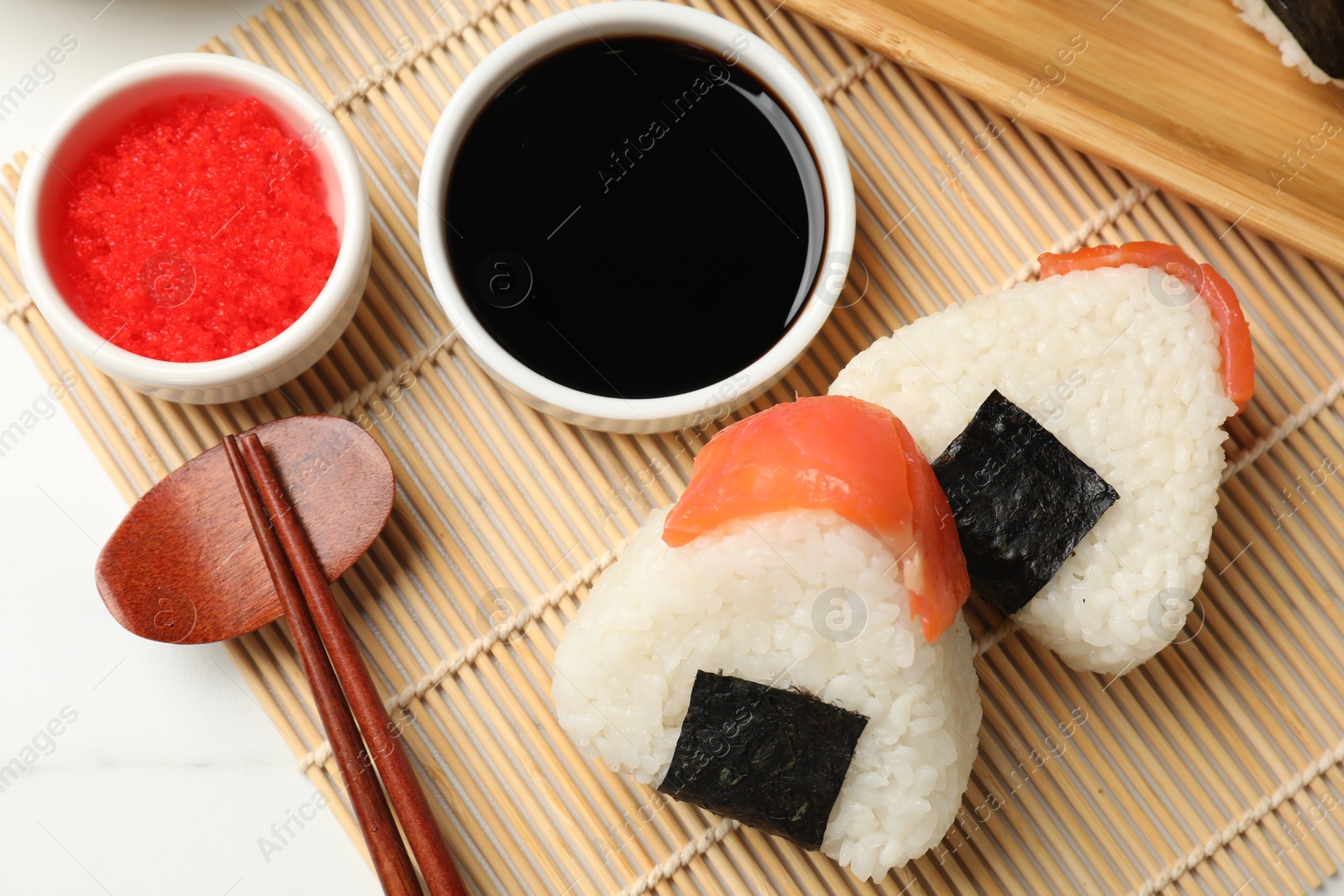 Photo of Tasty onigiri (Japanese rice balls) served on white table, flat lay