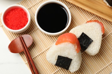 Photo of Tasty onigiri (Japanese rice balls) served on white table, flat lay