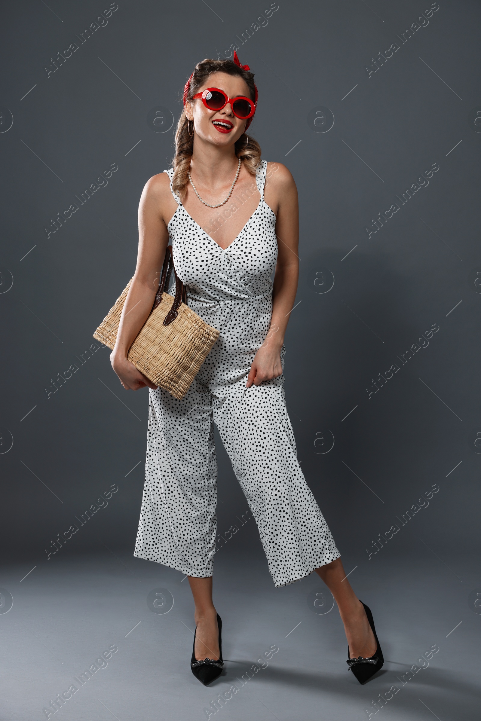 Photo of Happy pin-up woman with bag posing on grey background