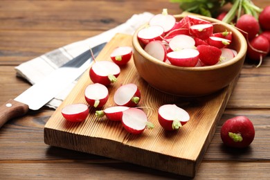 Photo of Fresh cut and whole radishes on wooden table, closeup