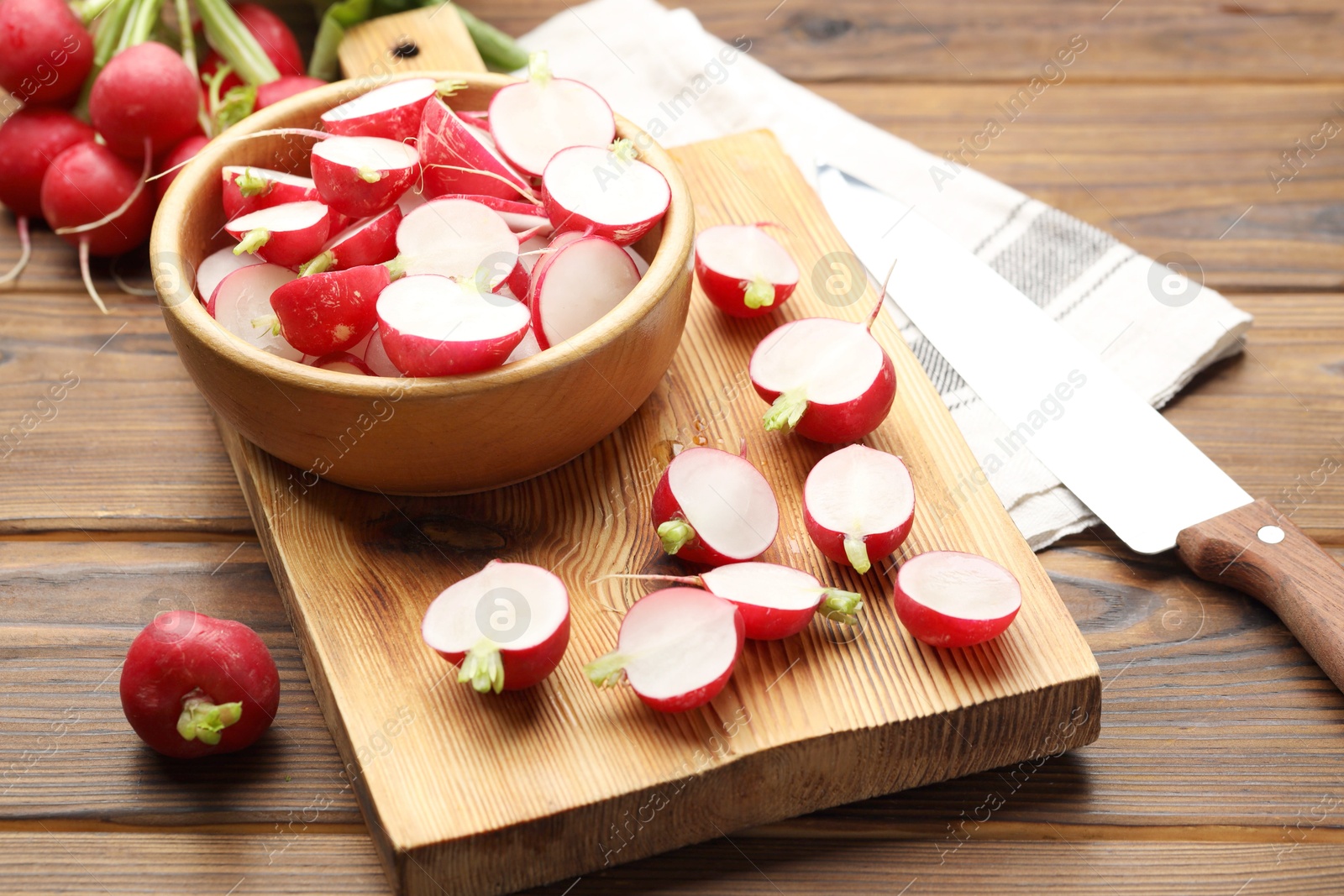 Fresh cut and whole radishes on wooden table, closeup Photo of Fresh cut and whole radishes on wooden table, closeup