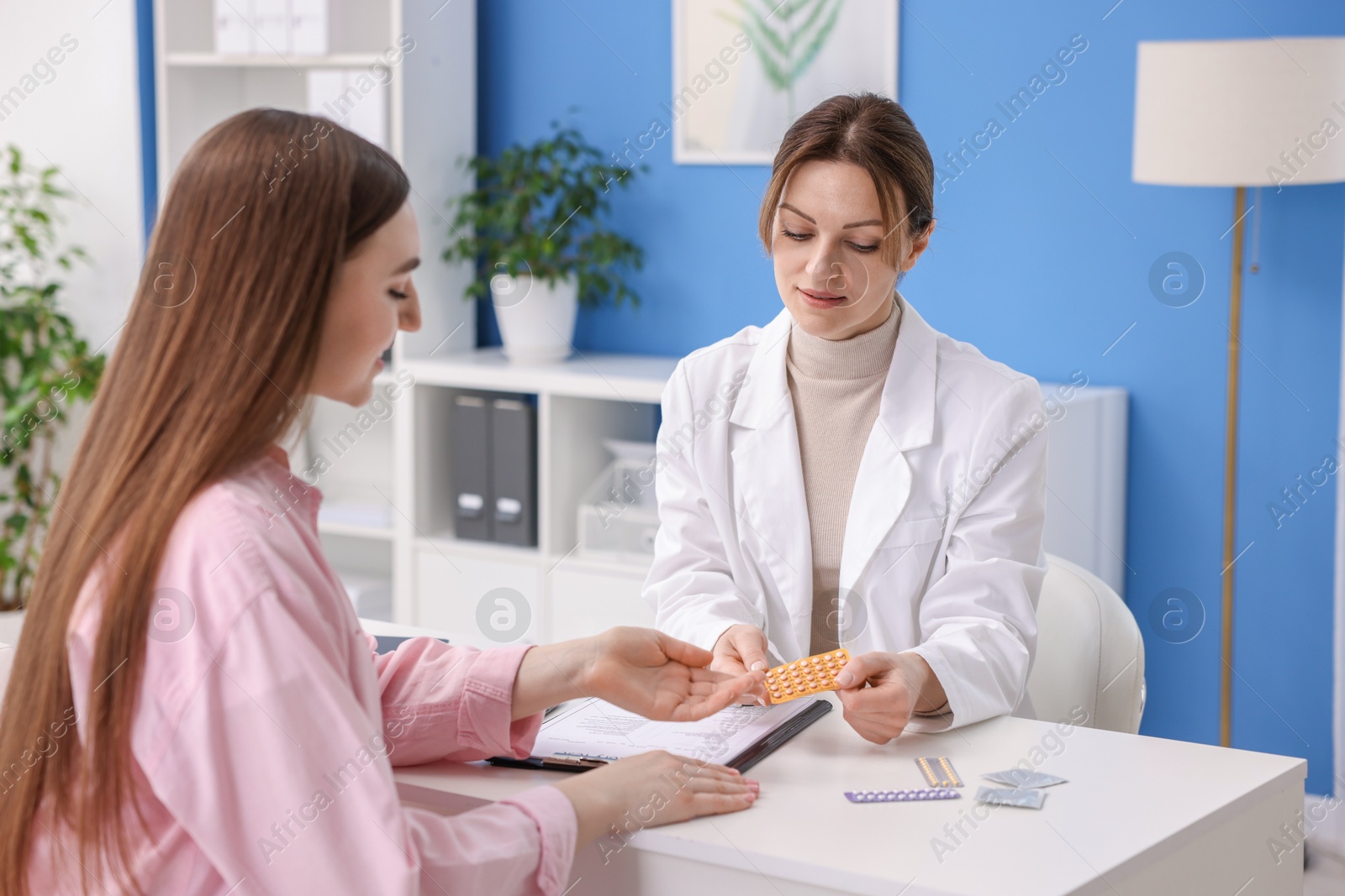 Photo of Gynecologist recommending contraceptive pills to woman in clinic