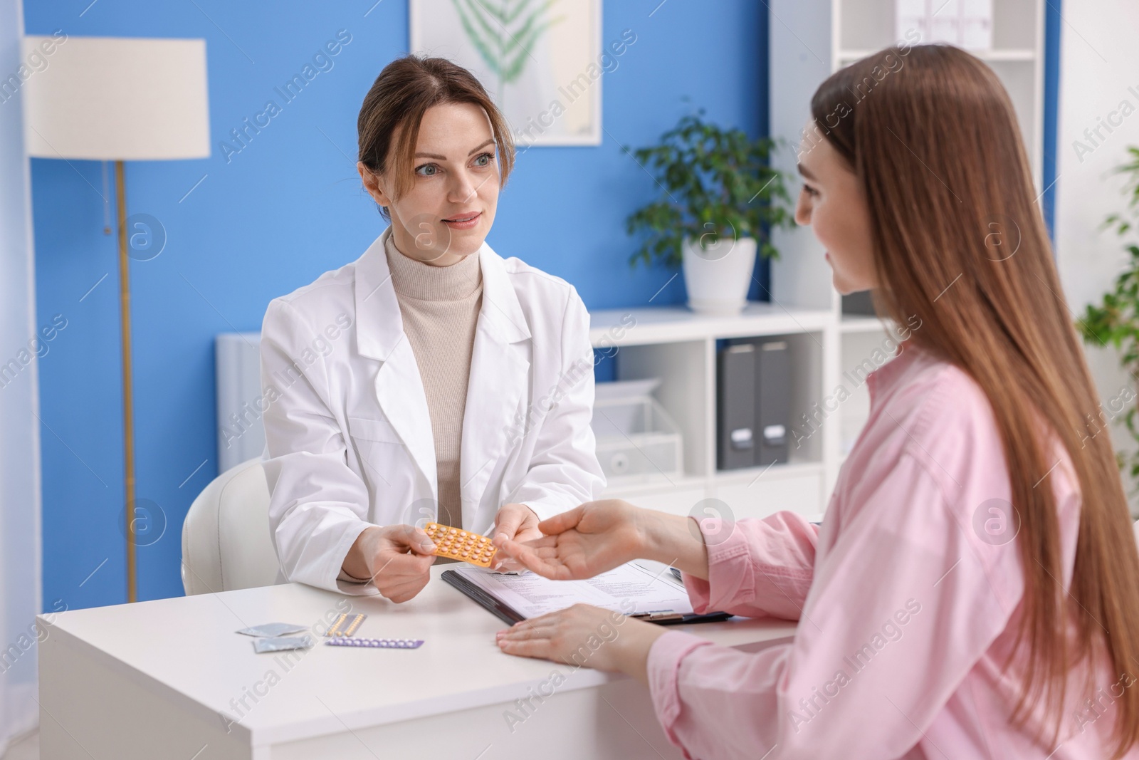 Photo of Gynecologist recommending contraceptive pills to woman in clinic