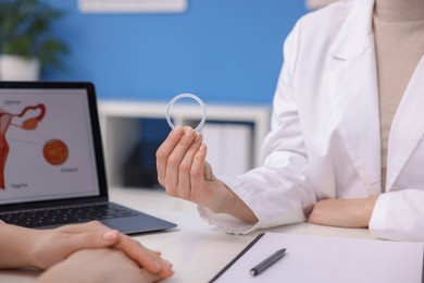 Contraception. Gynecologist recommending vaginal ring to woman in clinic, closeup