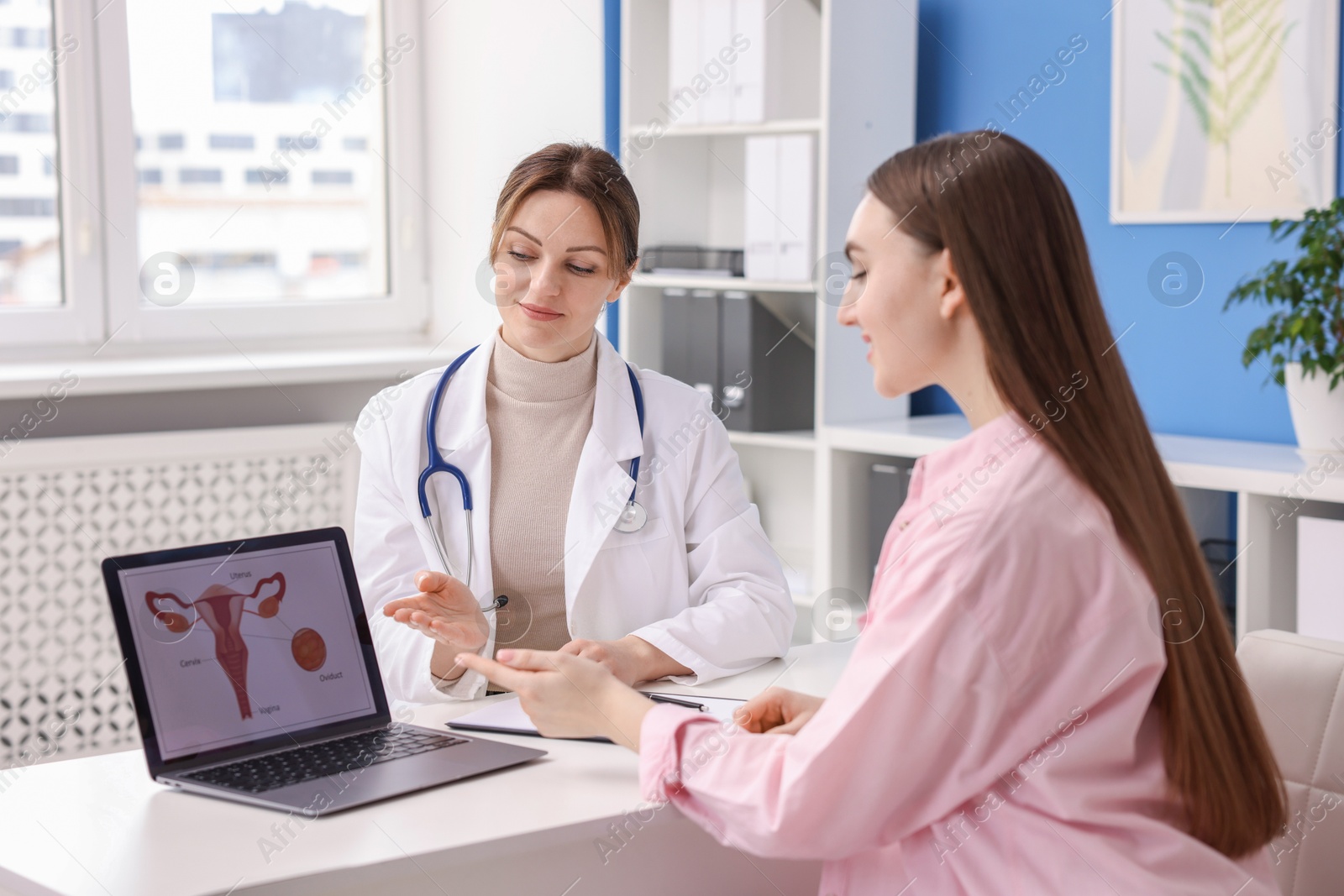 Photo of Contraception. Gynecologist showing image of female reproductive system to woman in clinic