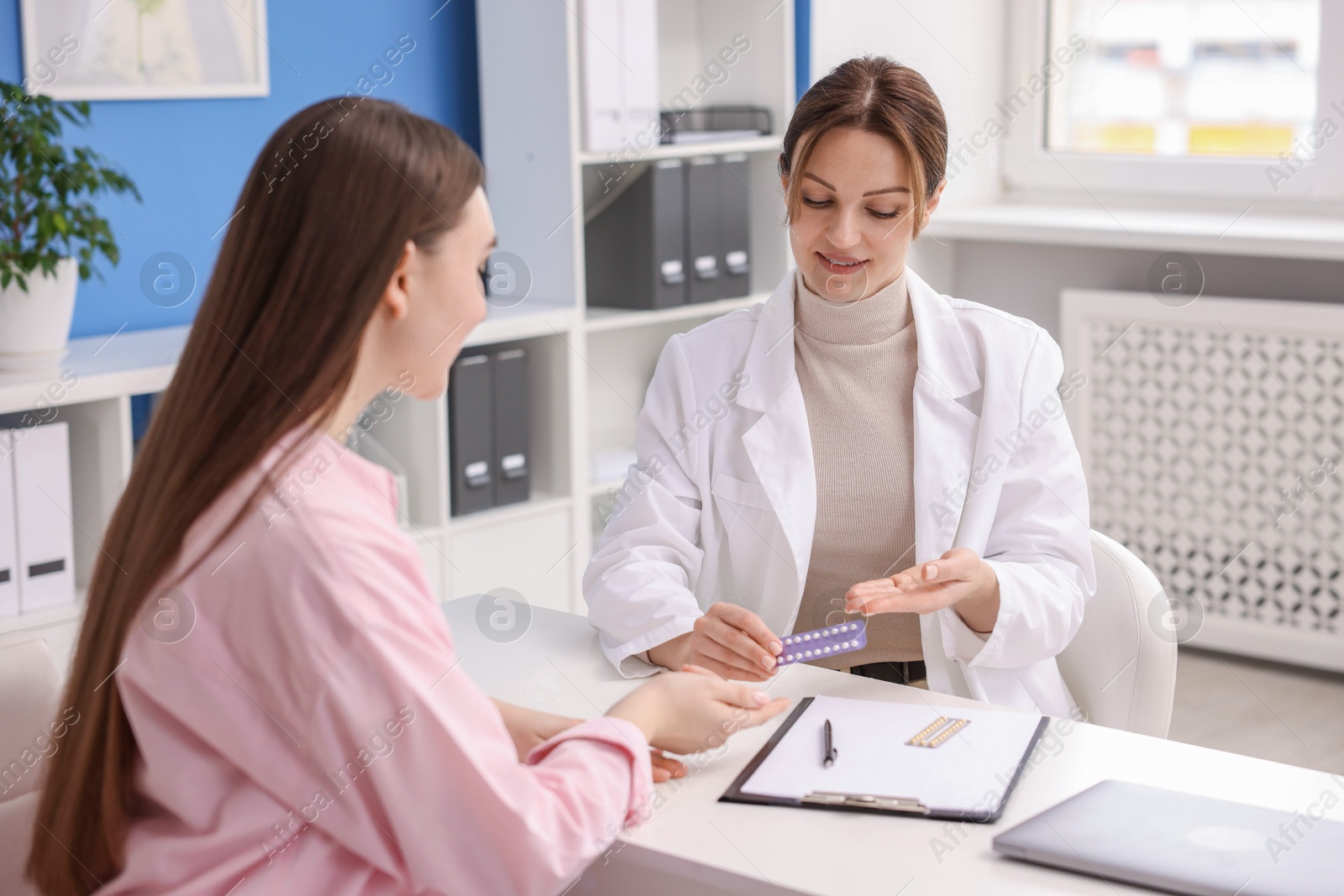 Photo of Gynecologist recommending contraceptive pills to woman in clinic