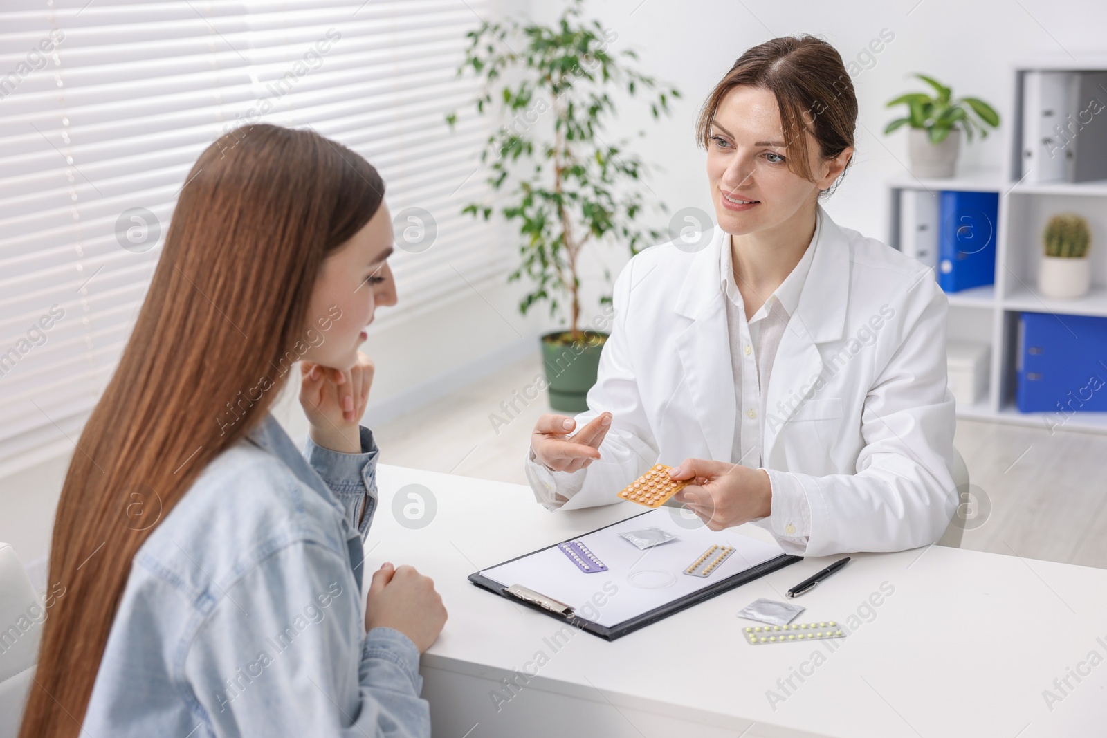 Photo of Gynecologist recommending contraceptive pills to woman in clinic