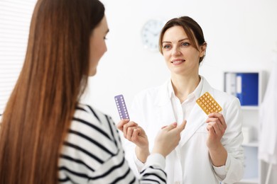 Gynecologist recommending contraceptive pills to woman in clinic