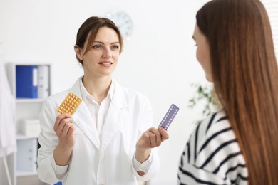 Gynecologist recommending contraceptive pills to woman in clinic