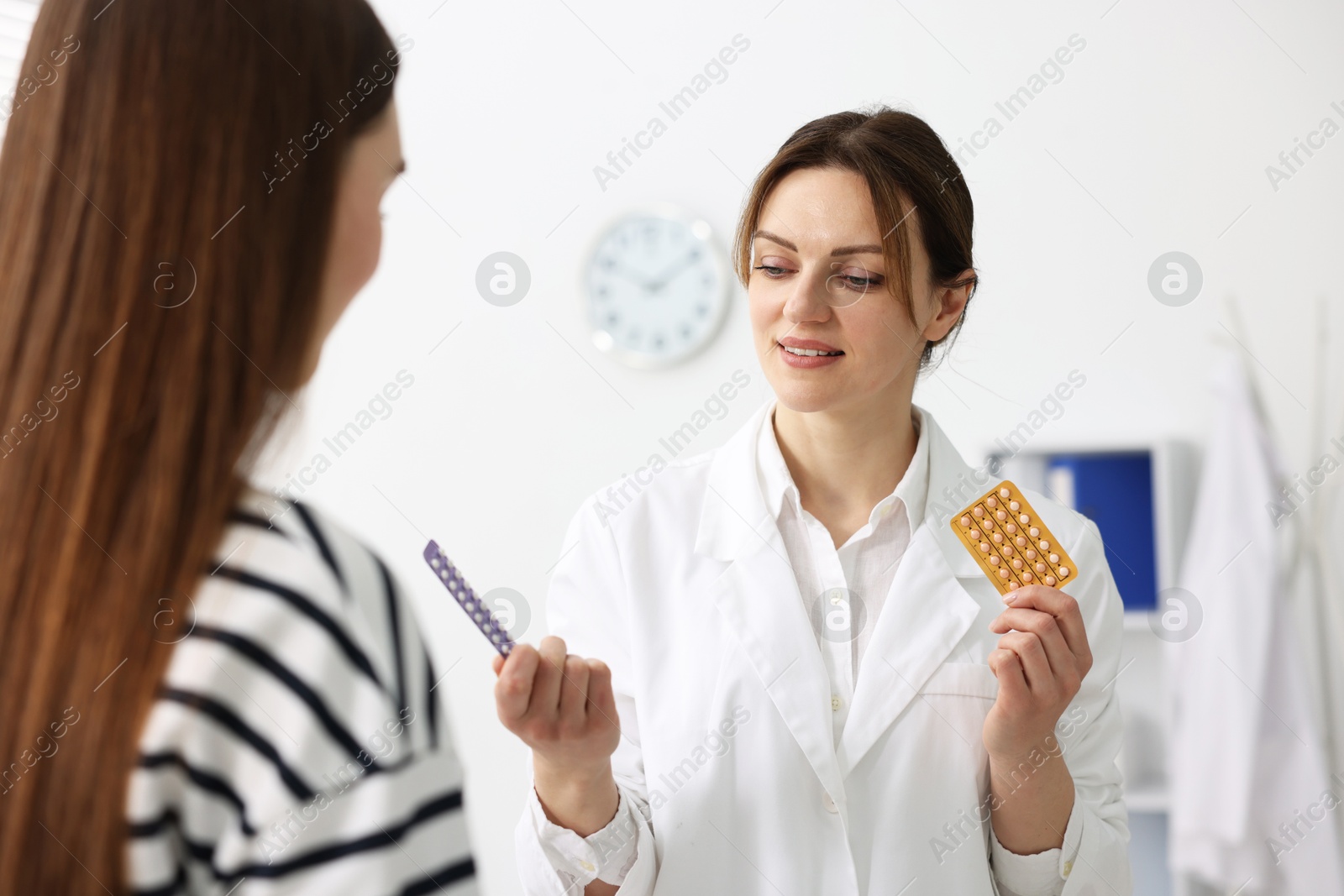 Photo of Gynecologist recommending contraceptive pills to woman in clinic