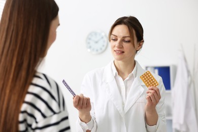 Gynecologist recommending contraceptive pills to woman in clinic