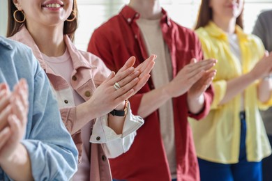 People applauding during meeting indoors, closeup view