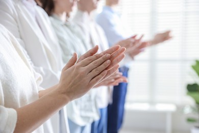 Photo of People applauding during meeting indoors, closeup view