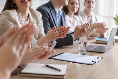 People applauding at table in office, closeup