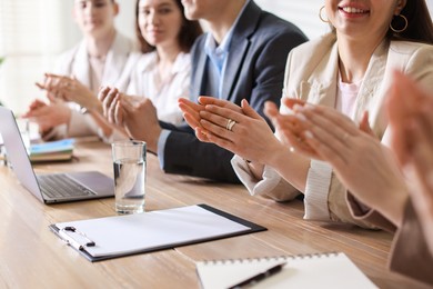 Photo of People applauding at table in office, closeup