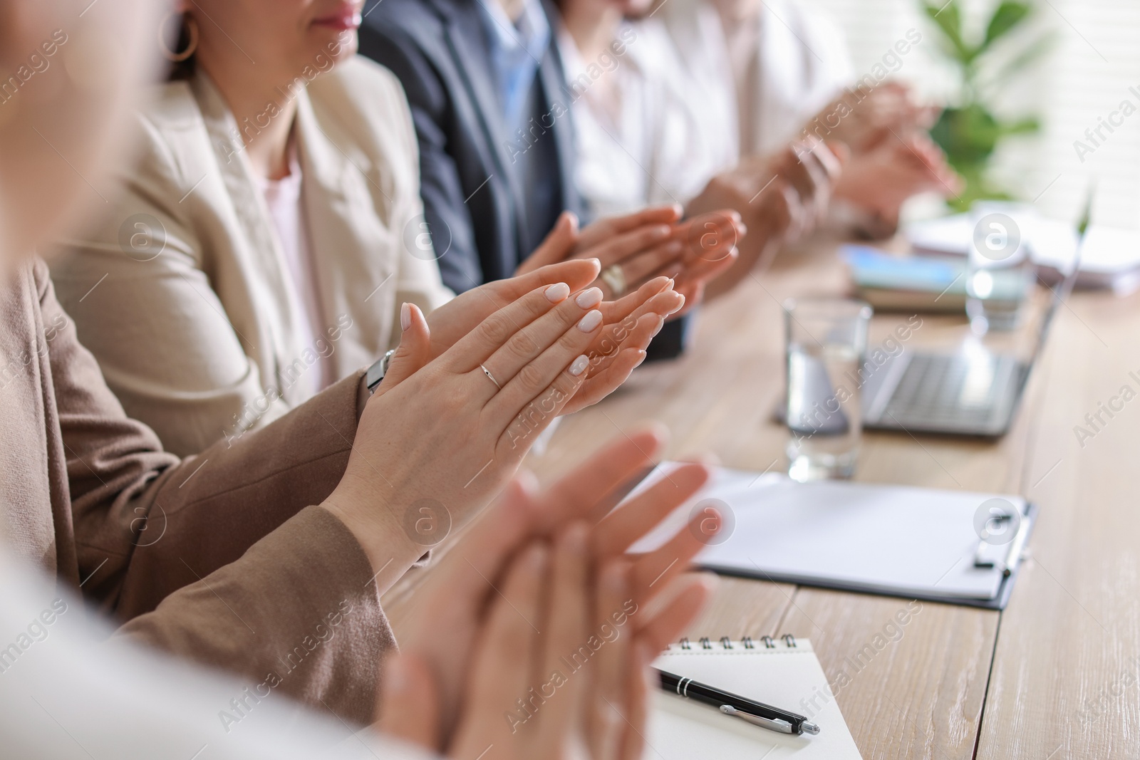 Photo of People applauding at table in office, closeup