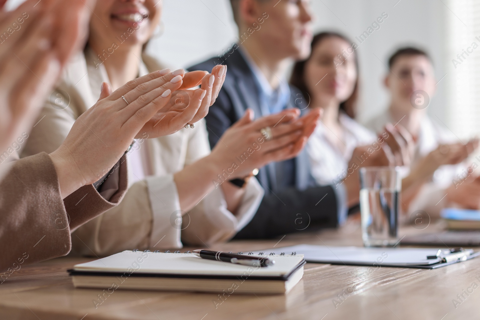 Photo of People applauding at table in office, closeup