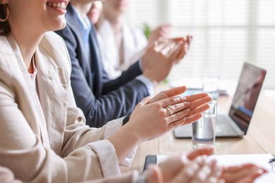 People applauding at table in office, closeup