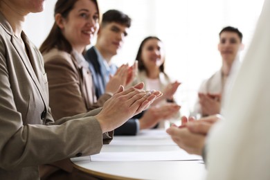 Photo of People applauding at table in office, closeup