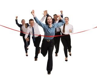 Photo of Competition concept. Happy businesswoman crossing red finish line ahead of her colleagues on white background