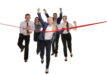 Photo of Competition concept. Happy businesswoman crossing red finish line ahead of her colleagues on white background