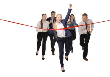 Competition concept. Happy businesswoman crossing red finish line ahead of her colleagues on white background