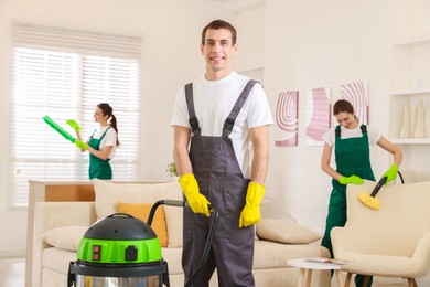 Photo of Professional cleaning service team working in room