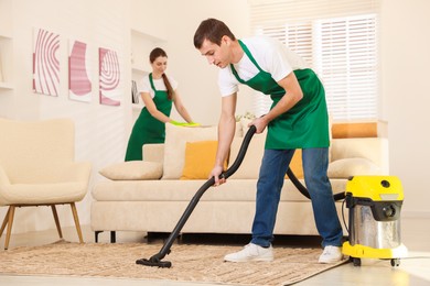 Photo of Professional cleaning service team working in room