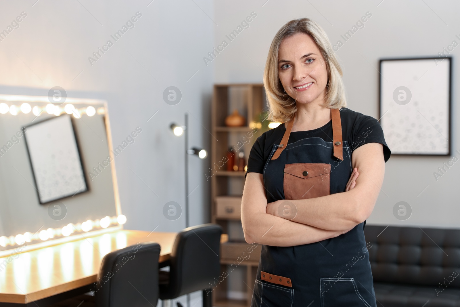 Photo of Portrait of smiling hairdresser in beauty salon, space for text