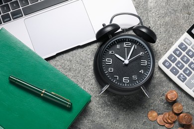 Photo of Time to pay taxes. Alarm clock, laptop, calculator, coins and notebook on grey textured table, flat lay