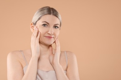 Portrait of beautiful woman on beige background. Space for text