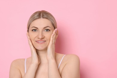 Portrait of beautiful woman on pink background. Space for text