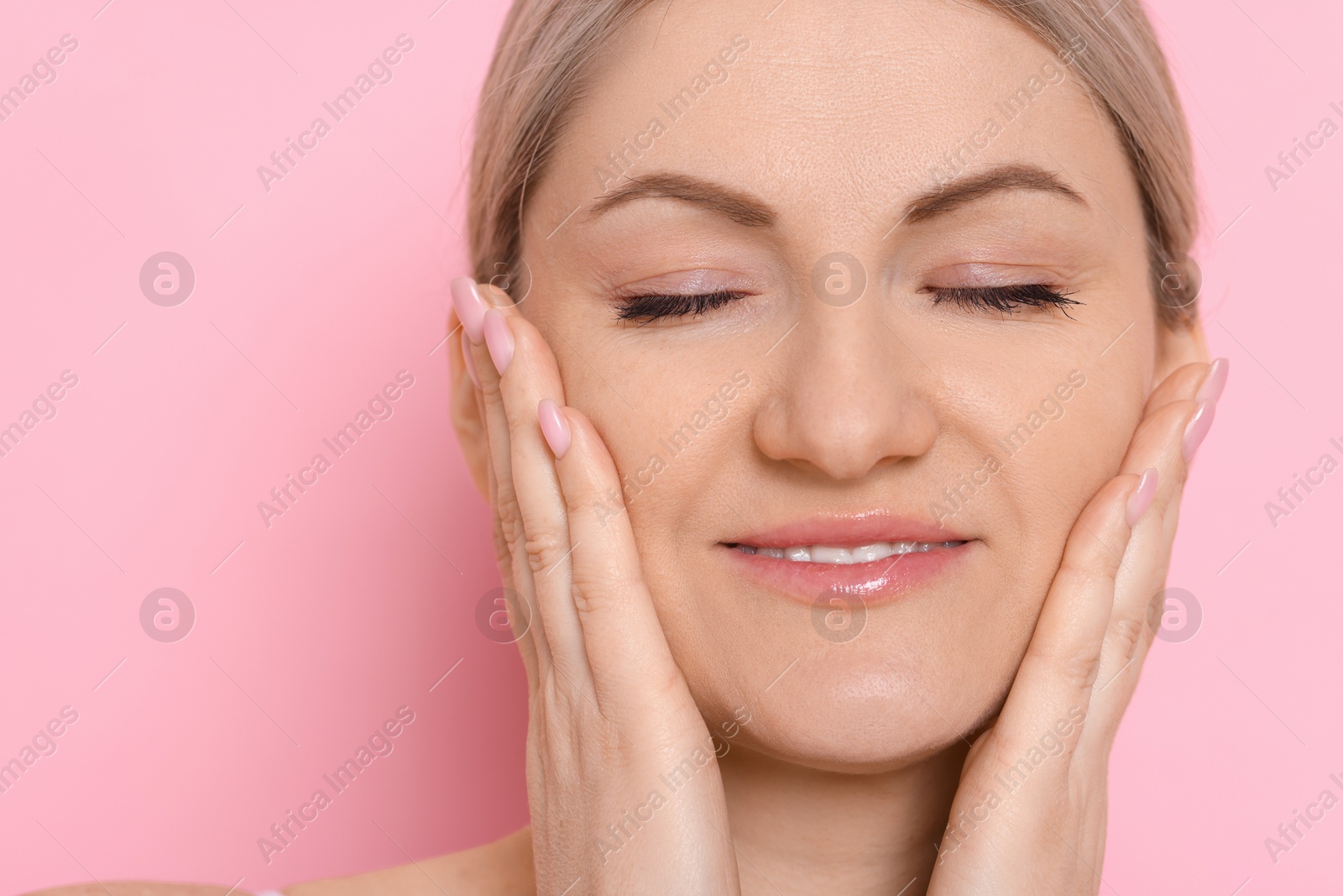 Photo of Portrait of beautiful woman on pink background