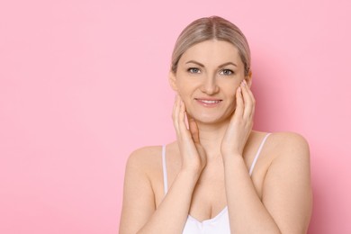 Portrait of beautiful woman on pink background. Space for text