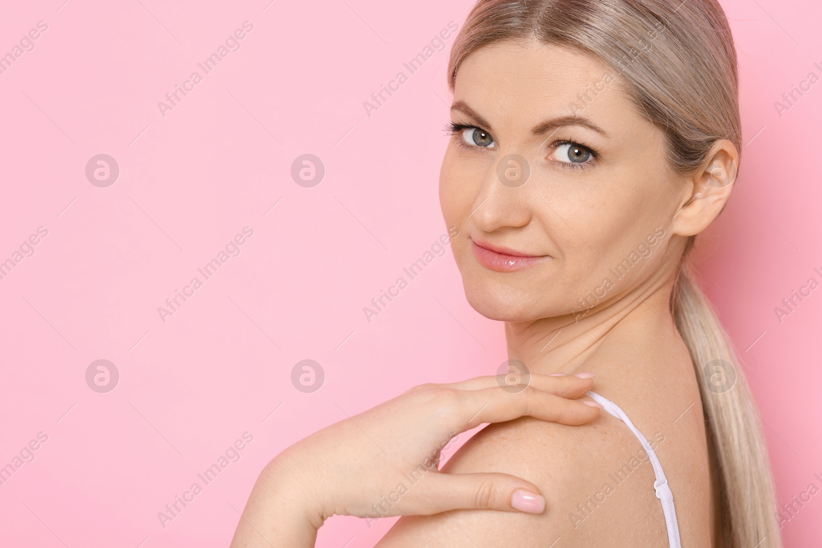 Photo of Portrait of beautiful woman on pink background. Space for text