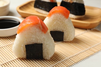 Photo of Tasty onigiri (Japanese rice balls) served on white table, closeup