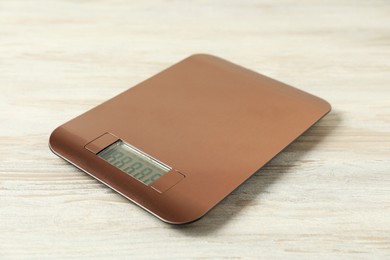 Photo of Modern electronic kitchen scale on wooden table, closeup