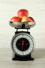 Photo of Retro mechanical kitchen scale with apples on wooden table