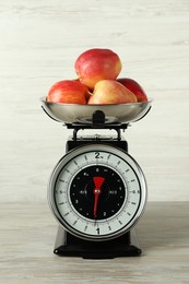 Photo of Retro mechanical kitchen scale with apples on wooden table