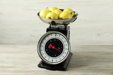 Photo of Retro mechanical kitchen scale with apples on wooden table