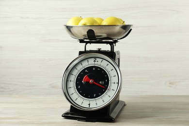 Photo of Retro mechanical kitchen scale with apples on wooden table