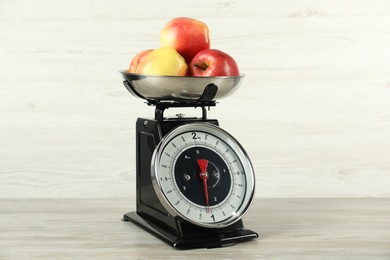 Photo of Retro mechanical kitchen scale with apples on wooden table