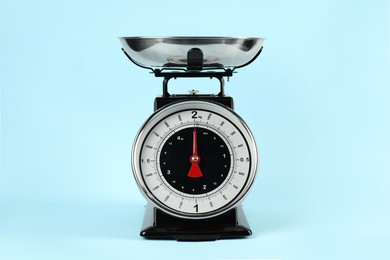 Photo of One mechanical kitchen scale on light blue background