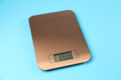 Photo of One electronic kitchen scale on light blue background