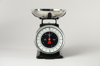 Photo of Mechanical kitchen scale with bowl on light grey background