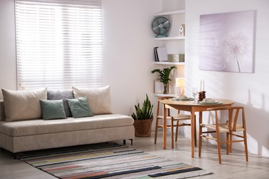 Photo of Stylish table setting, chairs and sofa in dining room. interior design