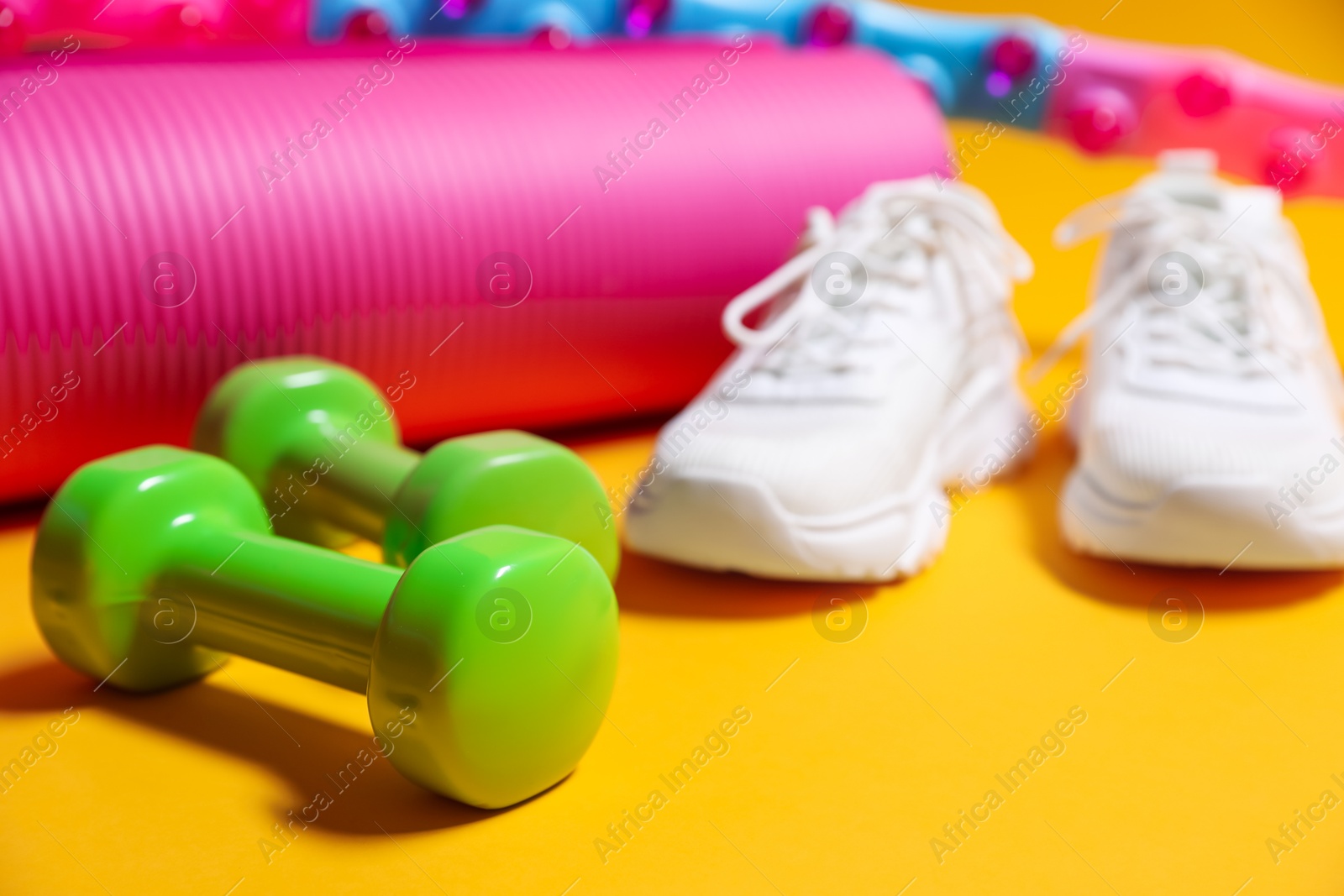 Photo of Different gym stuff on yellow background, closeup