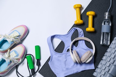 Photo of Different gym stuff and headphones on white background, flat lay. Space for text