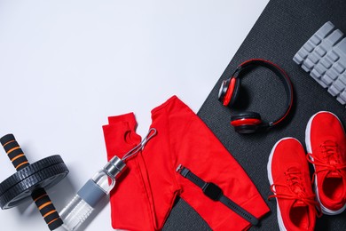 Photo of Different gym stuff and headphones on white background, flat lay. Space for text