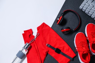 Photo of Different gym stuff and headphones on white background, flat lay. Space for text